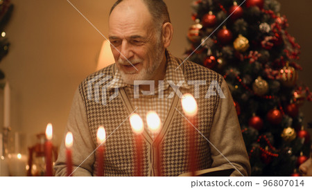 Senior man reads Bible on family Christmas dinner 96807014