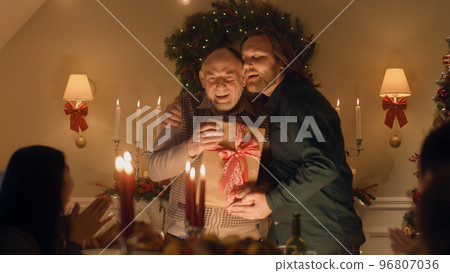 Man giving Christmas gift to senior father 96807036