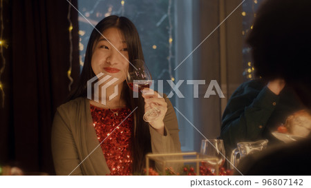 Asian woman drinks wine at Christmas party Asian woman drinks wine at Christmas party 96807142