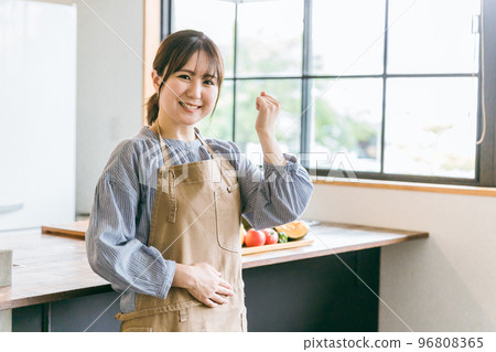 一位亞洲女性,她是家庭主婦、管家或烹飪人員,在家裡的廚房或咖啡館裡圍著圍裙擺出拳頭姿勢 一位亞洲女性,她是家庭主婦、管家或烹飪人員,在家裡的廚房或咖啡館裡圍著圍裙擺出拳頭姿勢 96808365