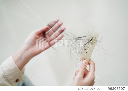Asian woman have problem with long hair loss attach to comb brush. Asian woman have problem with long hair loss attach to comb brush. 96808507