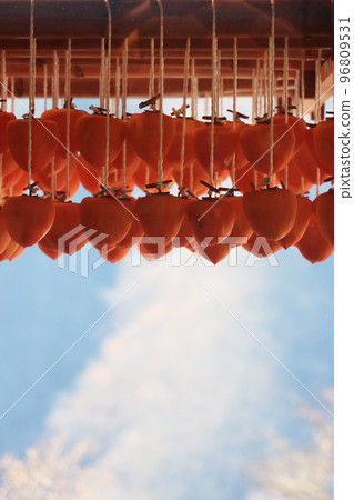 Dried persimmons hanging under the eaves Making dried persimmons A winter tradition in front of the eaves of a farmhouse Dried persimmons hanging under the eaves Making dried persimmons A winter tradition in front of the eaves of a farmhouse 96809531