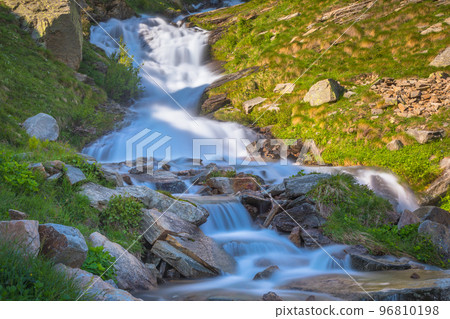 Ethereal waterfall and alpine meadows at springtime, Gran Paradiso Alps, Italy 96810198