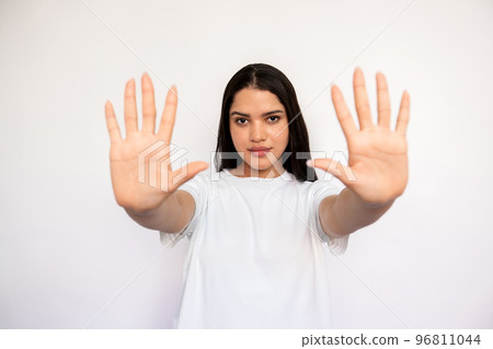 Portrait of confident young woman making stop gesture Portrait of confident young woman making stop gesture 96811044
