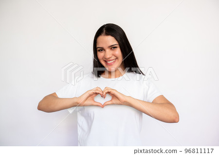 Portrait of happy young woman making heart gesture Portrait of happy young woman making heart gesture 96811117