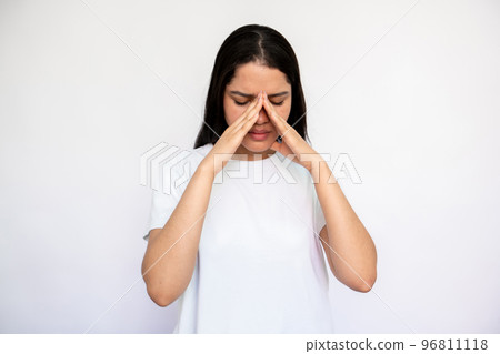 Portrait of upset young woman rubbing nose Portrait of upset young woman rubbing nose 96811118