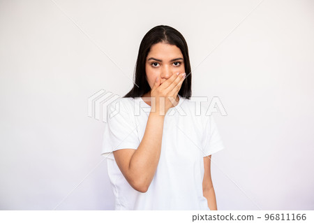 Portrait of terrified young woman covering mouth with hand Portrait of terrified young woman covering mouth with hand 96811166