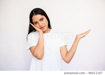 Portrait of bored young woman leaning on hand and showing 96811167