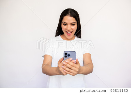Portrait of excited young woman reading newsletter on smartphone 96811180