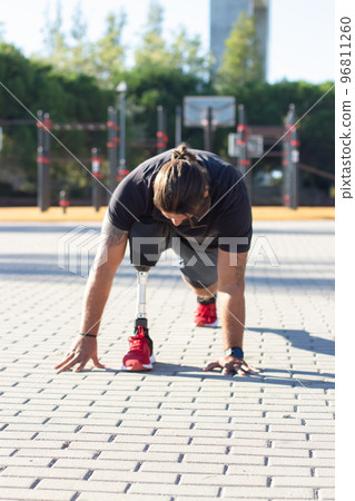 Portrait of man with disability training his legs outdoors 96811260