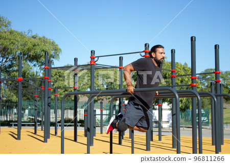 Portrait of handsome man with disability doing push-ups on bars Portrait of handsome man with disability doing push-ups on bars 96811266
