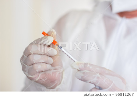 Close-up of female medical workers hands with new syringe Close-up of female medical workers hands with new syringe 96811267