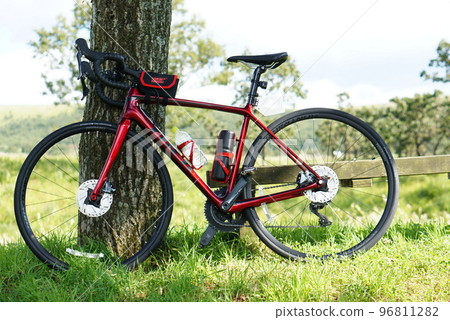 Cycling through the grasslands on a road bike 96811282