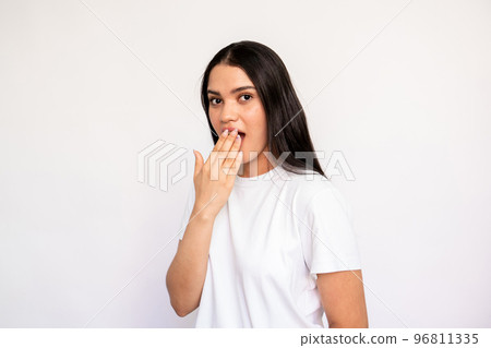 Portrait of shocked young woman covering mouth with hand Portrait of shocked young woman covering mouth with hand 96811335