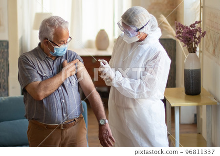 Portrait of senior man and female doctor using antiseptic Portrait of senior man and female doctor using antiseptic 96811337
