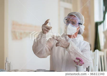 Portrait of female doctor with vial of vaccine and syringe 96811340