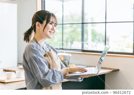 Cafe staff asian woman watching using laptop in kitchen 96812672