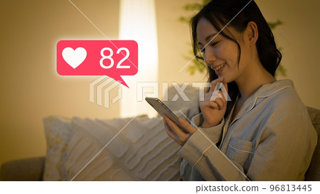 穿著睡衣的年輕女子操作智能手機 96813445