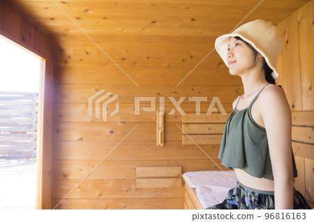 戴著桑拿帽進入室外桑拿浴室的桑拿女孩 戴著桑拿帽進入室外桑拿浴室的桑拿女孩 96816163