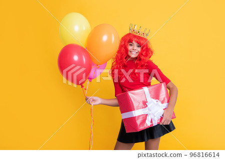 happy child in crown with present box and party balloon on yellow background 96816614