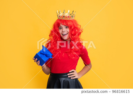 positive child in princess crown with present box on yellow background positive child in princess crown with present box on yellow background 96816615