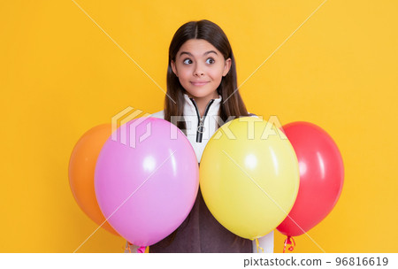 happy amazed kid with party colorful balloons on yellow background 96816619