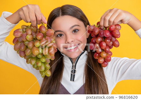 happy kid with grapes bunch on yellow background 96816620