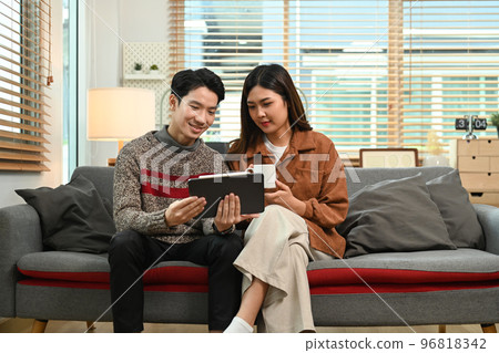 Young asian couple using digital tablet, enjoy spending time together on winter holidays Young asian couple using digital tablet, enjoy spending time together on winter holidays 96818342