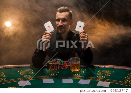 Bearded man showing poker cards on smoke black background 96818747