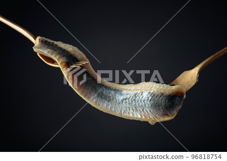 Herring fillet in oil on a black background. Herring fillet in oil on a black background. 96818754