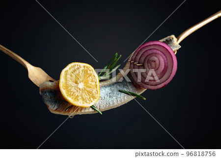 Herring fillet in oil with lemon, red onion, and rosemary. Herring fillet in oil with lemon, red onion, and rosemary. 96818756