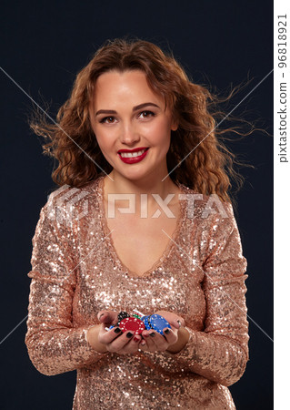 Casino concept. Portrait of young pretty caucasian woman, playing in casino. Roulette, poker chips, cards, wheel, black background 96818921