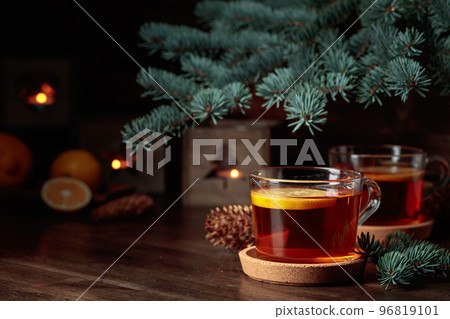 Tea with lemon and small Christmas lanterns on a wooden table. Tea with lemon and small Christmas lanterns on a wooden table. 96819101