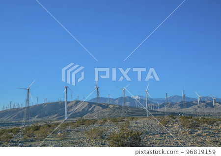 Windmills renewable energy generator againts blue sky background 96819159