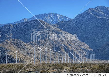 Windmills or windpumps for production of green energy against mountains Windmills or windpumps for production of green energy against mountains 96819171