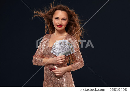 Image of lucky happy woman with brown long hair with fan of 100 dollar bills, lots of cash money, over black background Image of lucky happy woman with brown long hair with fan of 100 dollar bills, lots of cash money, over black background 96819408