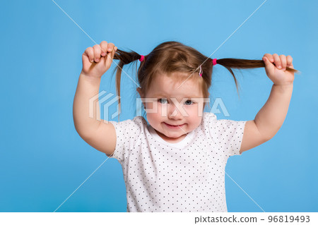Funny kid in white T-shirt on blue background. Little pretty girl isolated on blue background. Copy space for text. 96819493