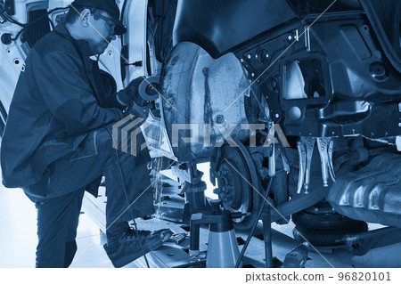 Repair service worker fix damaged car. Working with angle grinder to fix metal body. 96820101