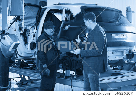 Auto mechanic and technician working in repair shop 96820107