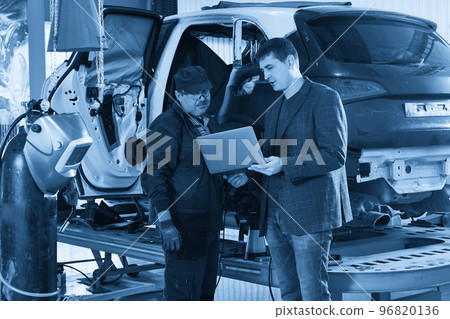 Auto mechanic and technician working in repair shop 96820136