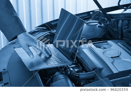 Car mechanic using computer in auto repair shop Car mechanic using computer in auto repair shop 96820359