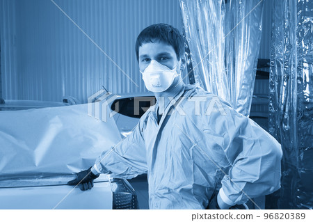 Mechanic covering car before painting in auto repair service 96820389