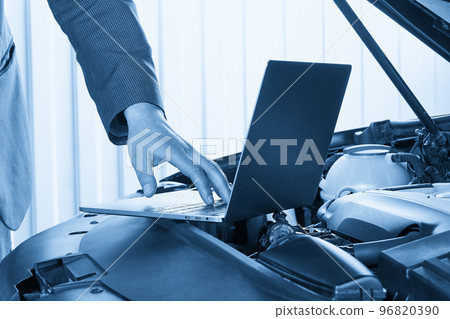Car mechanic using computer in auto repair shop 96820390