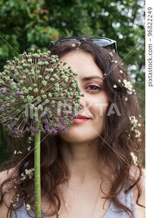 Beautiful woman 30 years old near plants in the summer garden. The road to a sustainable future, protection and unity with nature. Beautiful woman 30 years old near plants in the summer garden. The road to a sustainable future, protection and unity with nature. 96822249
