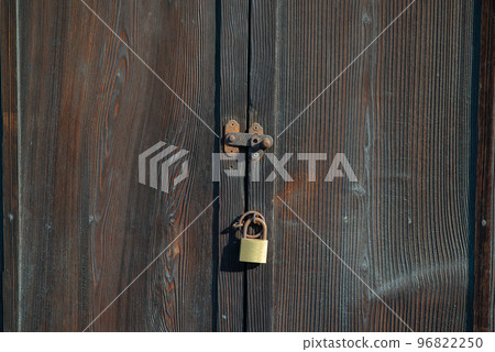 A lock on an old wooden door A lock on an old wooden door 96822250