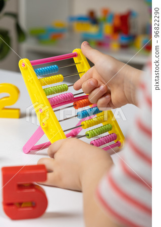 A small child learns to count on abacus, mathematics, arithmetic for children. 96822290