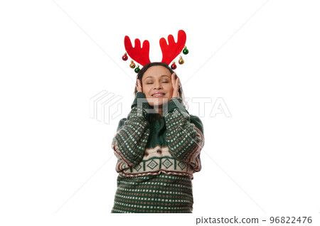 Attractive delightful woman putting hands on her face, smiling a beautiful smile, enjoying the upcoming Christmas and winter holidays, posing with her eyes closed over white background, Copy ad space Attractive delightful woman putting hands on her face, smiling a beautiful smile, enjoying the upcoming Christmas and winter holidays, posing with her eyes closed over white background, Copy ad space 96822476