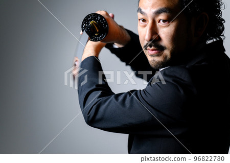 An office worker in a suit holding a sword An office worker in a suit holding a sword 96822780