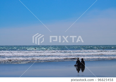 Two surfers resting on the beach in Miyazaki Prefecture 96825458