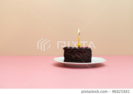 chocolate slice cake with candle on pink background-happy birthday tart -minimalistic image 96825881
